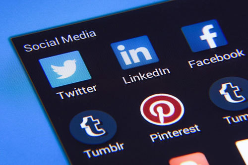 A phone screen with apps for Twitter, Facebook, LinkedIn, and Pinterest visible