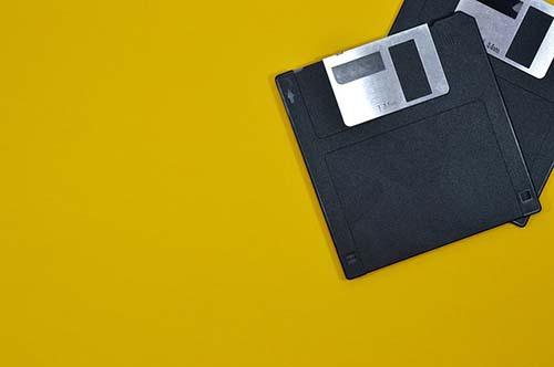 two_floppy_disks_on_yellow_background