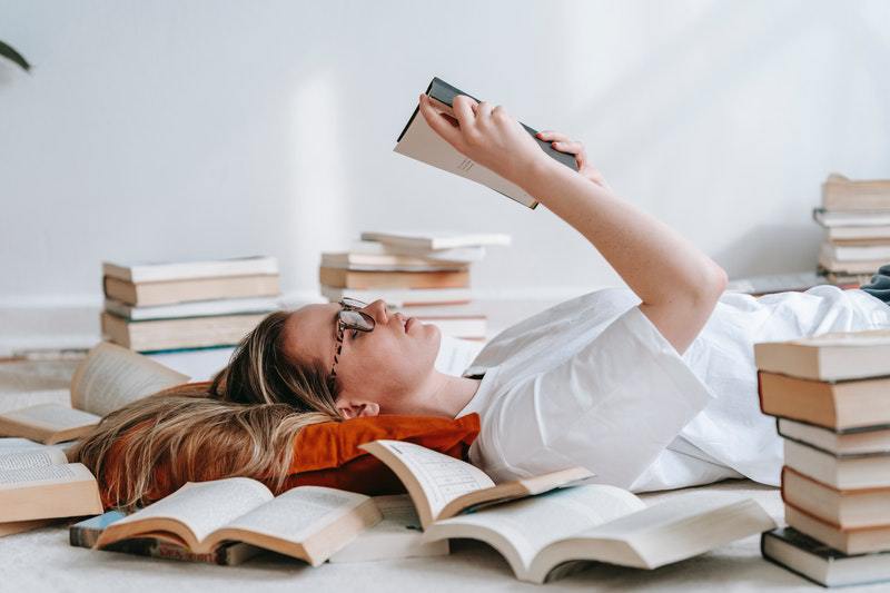 woman lying on the ground reading a book