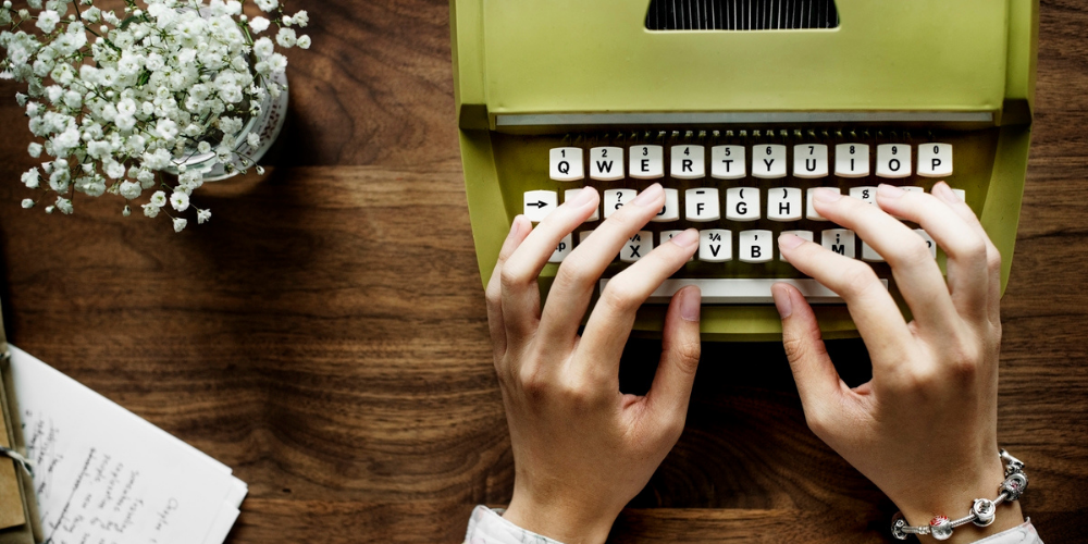 hands hovering over typewriter