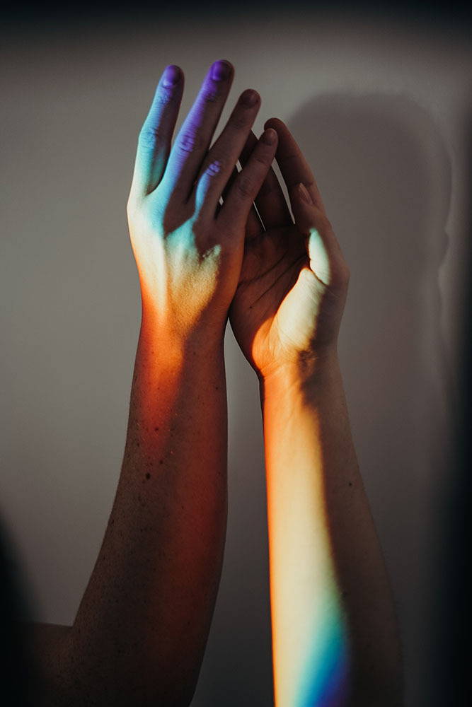 clasped Hands in Rainbow of Light