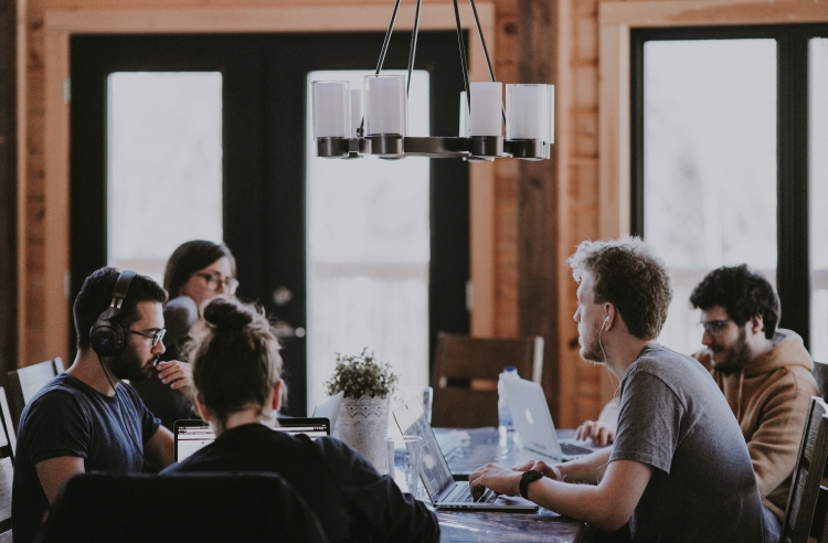 group of people talking at a table with papers in front of them