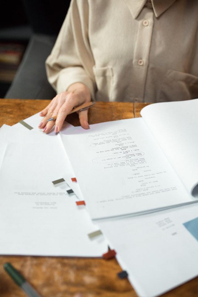 a person holding a notated script and sitting at a table