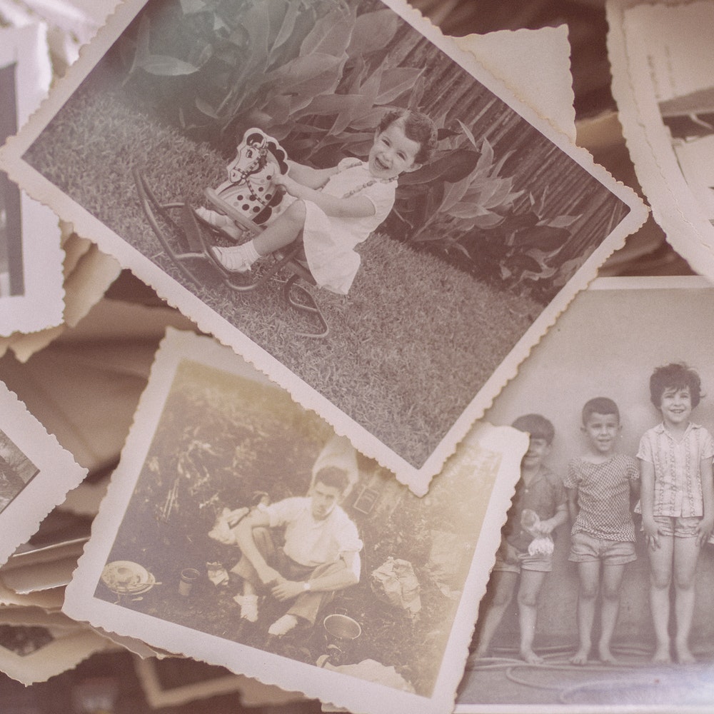 a stack of vintage black and white photographs showing children of various ages