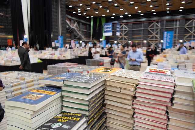 stacks of books on tables in a large exhibition hall